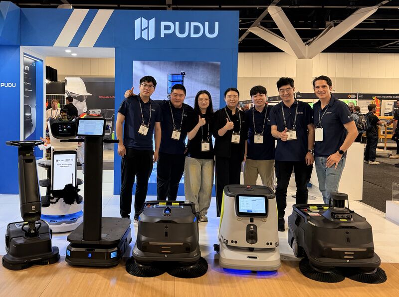 ERA Robotics and PUDU team members with commercial robots at the Workplace Health & Safety Show in Sydney