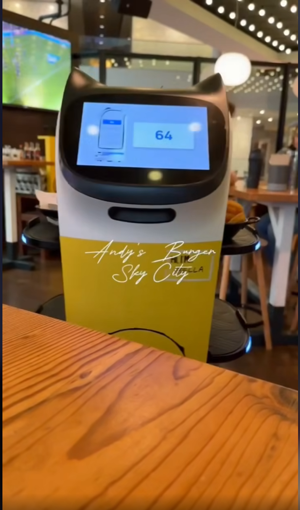 Original yellow and white PUDU BellaBot at a hospitality venue, from the ERA Robotics interview video
